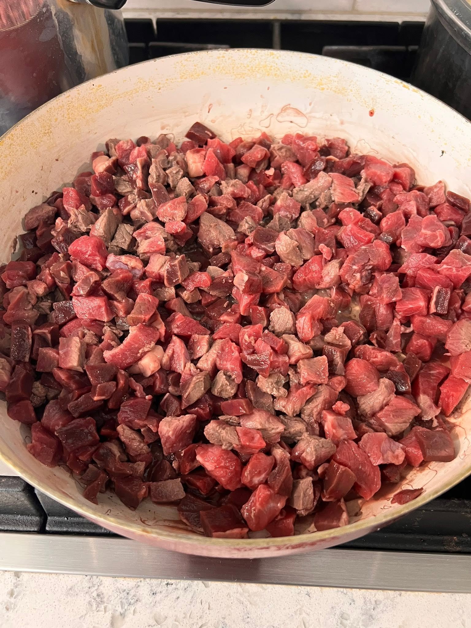 Diced beef and organ meat in a large pan during preparation