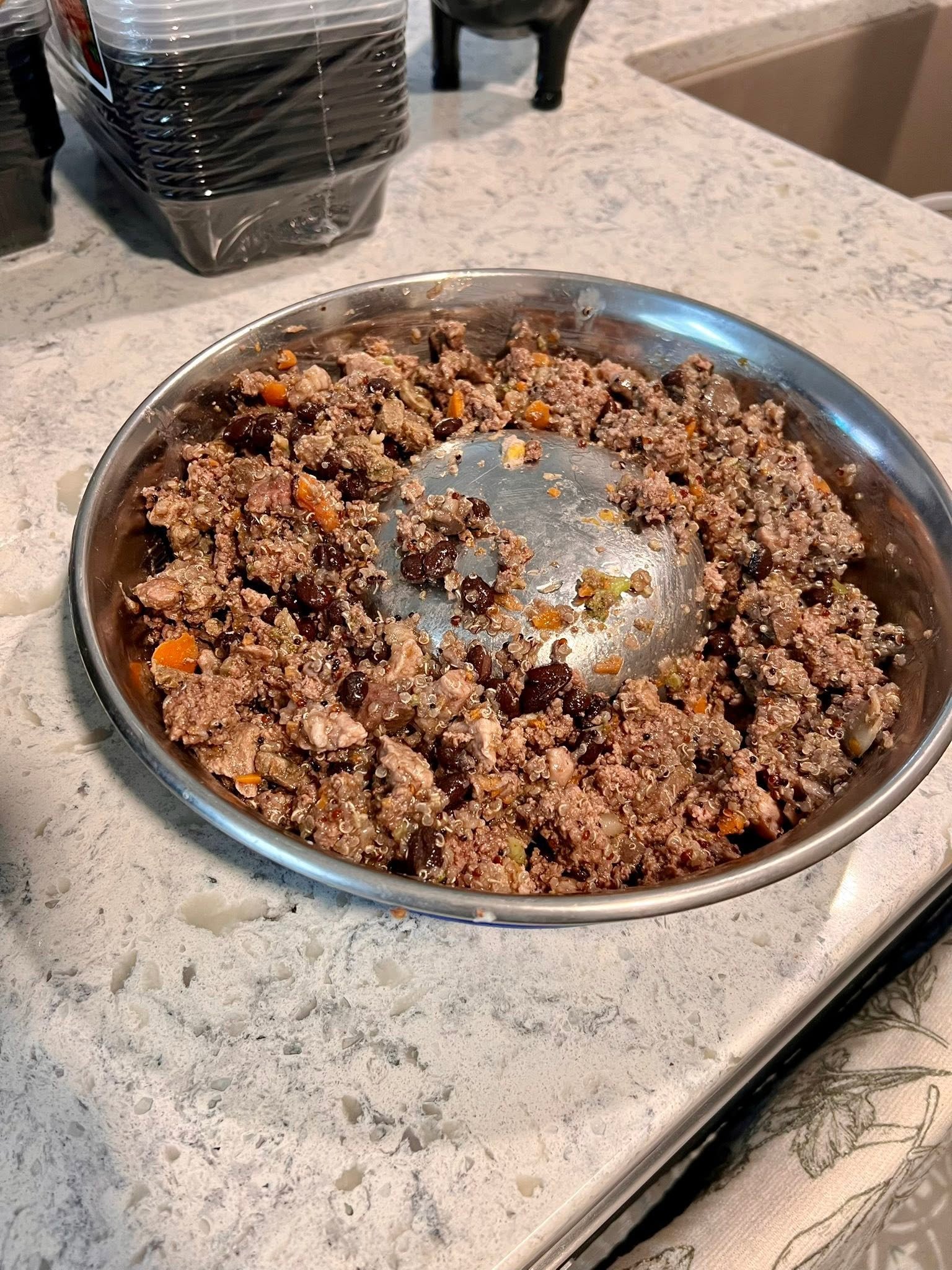 Meat and quinoa mixture with black beans in a stainless steel slow-feeder bowl