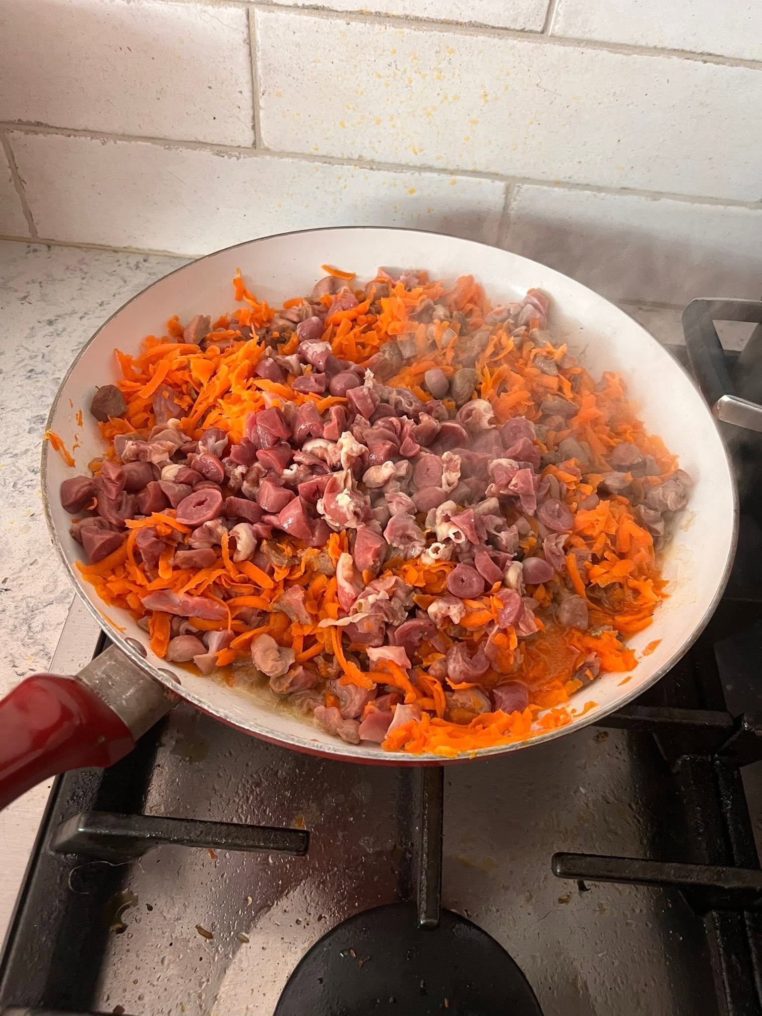 Chicken hearts and gizzards with shredded carrots during preparation