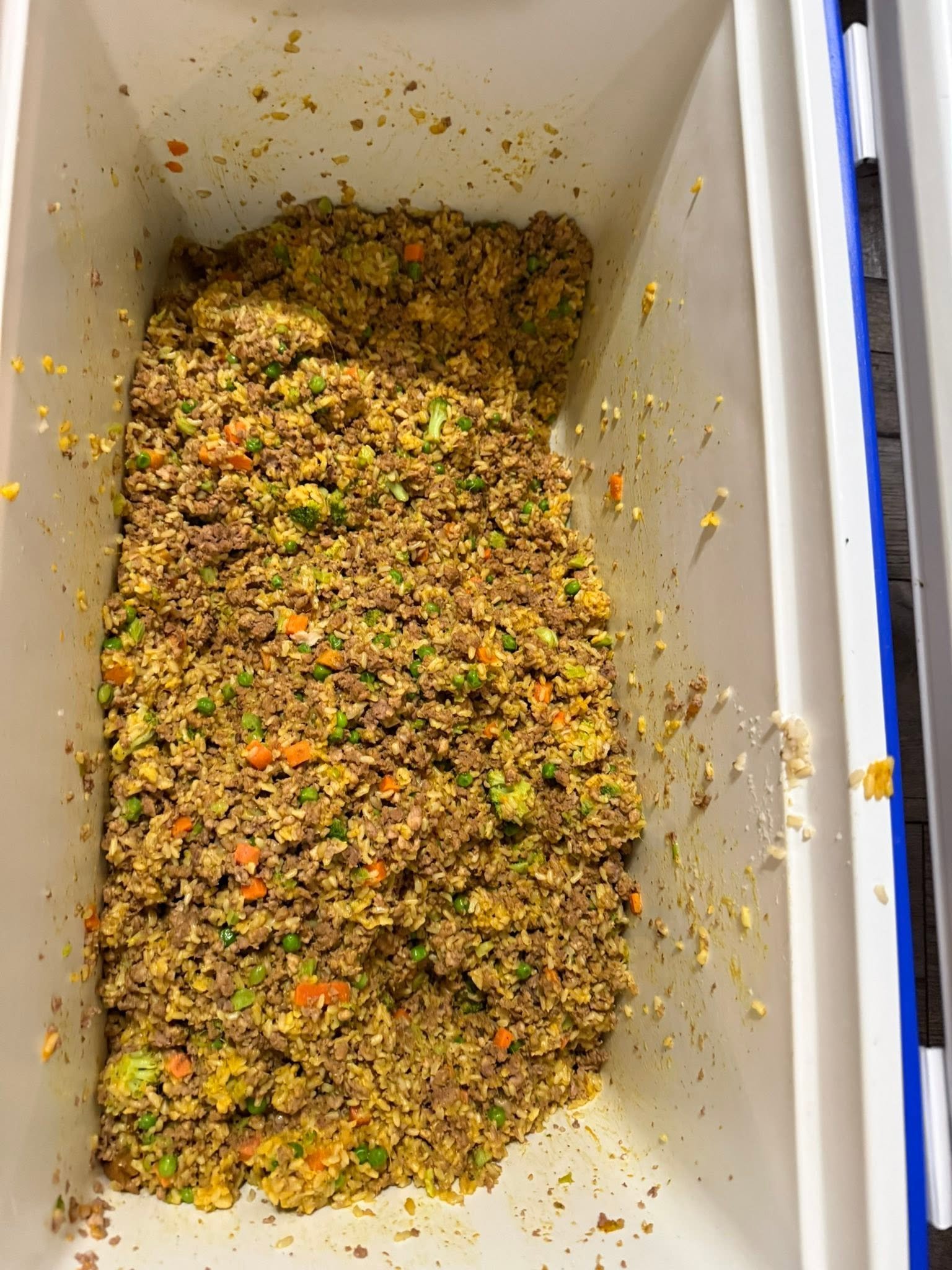 Ground meat rice and vegetables mixed in a large container
