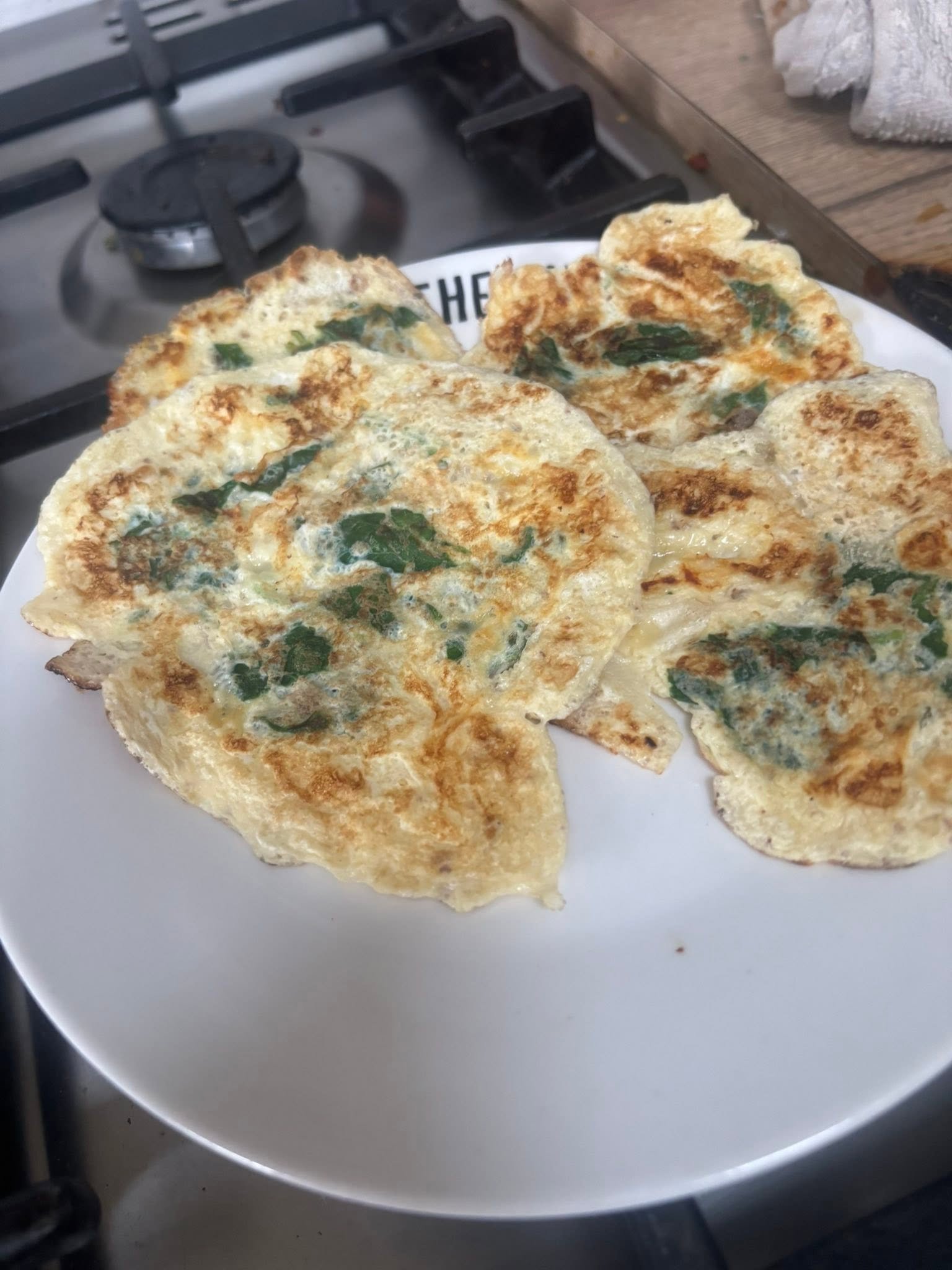 Several finished spinach omelettes arranged on a plate