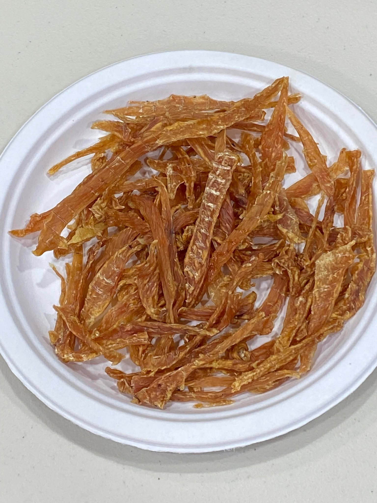 Chicken jerky strips spread on a white plate