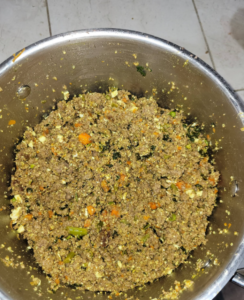 Meat quinoa egg and vegetable mixture in a metal bowl
