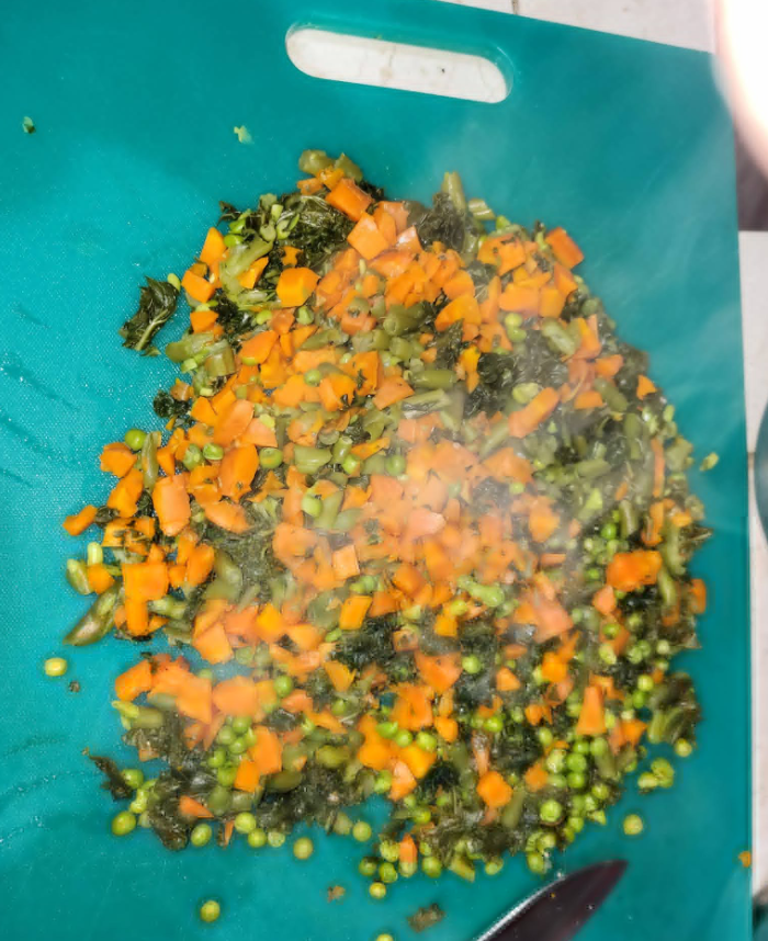 Chopped steamed vegetables on a cutting board