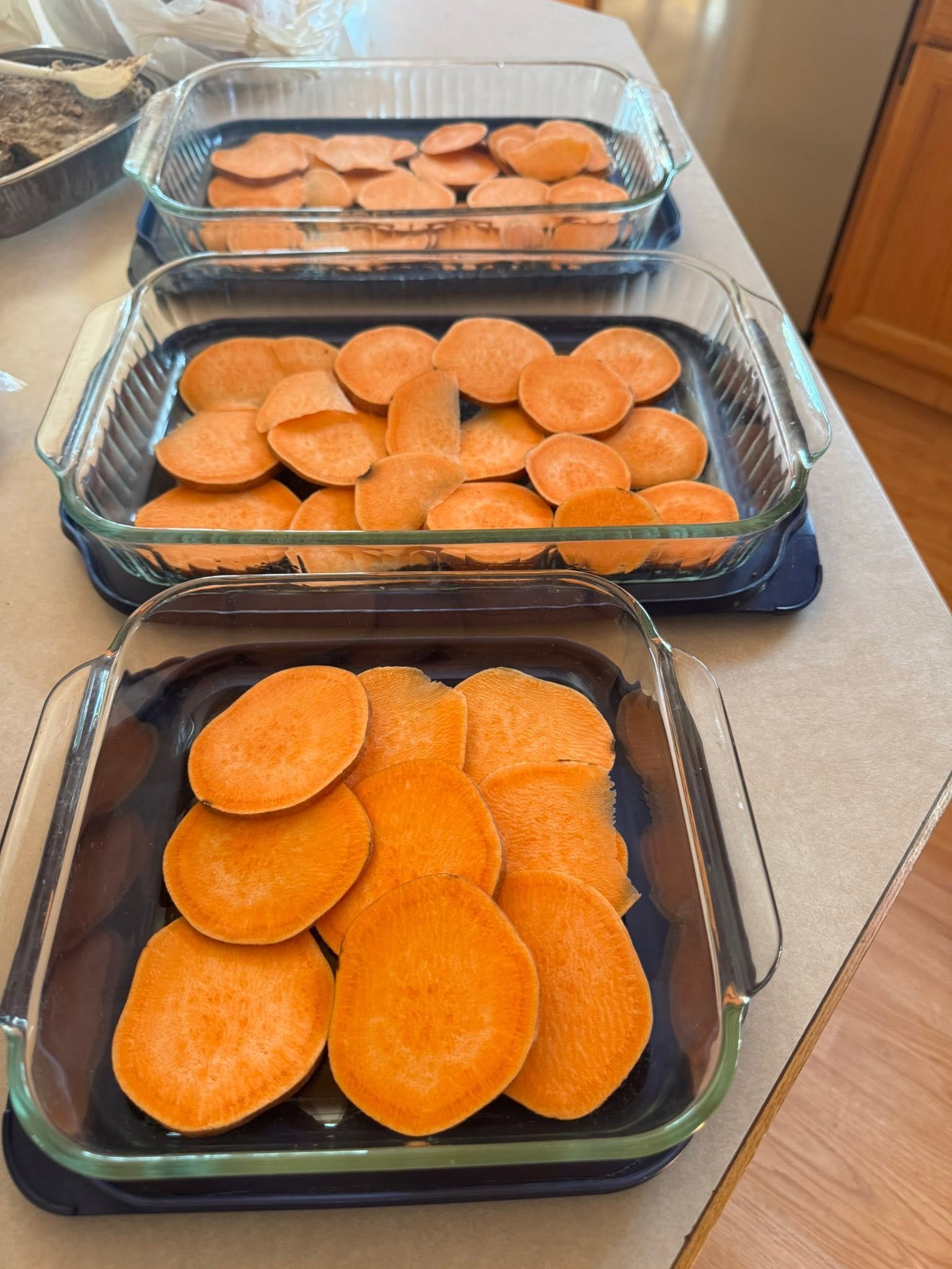 Sweet potato slices arranged in glass baking dishes