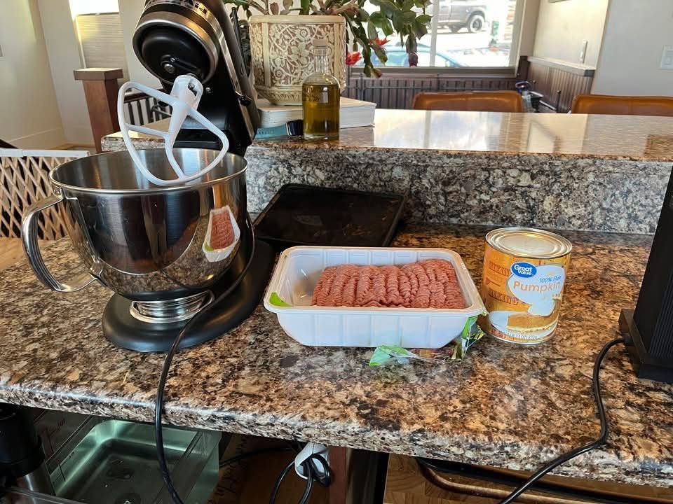 Ground turkey and canned pumpkin beside a stand mixer