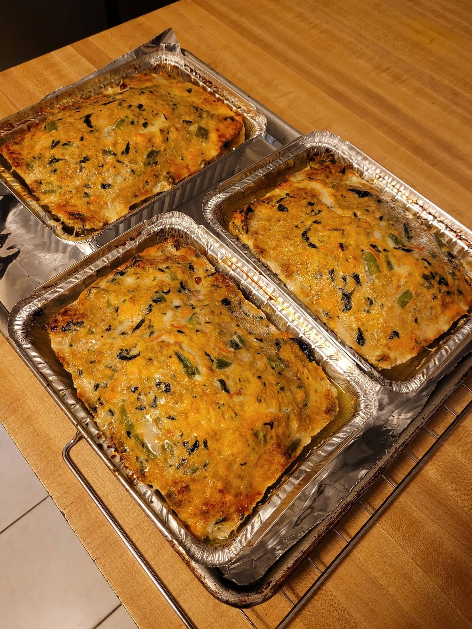 Three golden turkey meatloaves in pans on a baking sheet