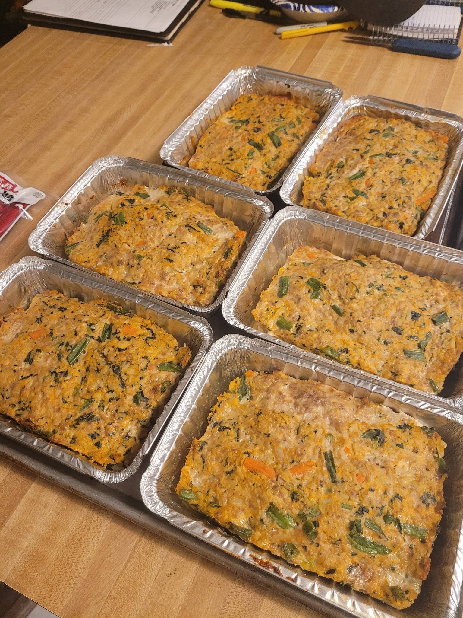 Several baked turkey and vegetable meatloaves in foil pans